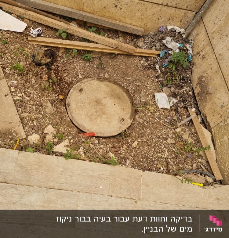 פתח ביוב מכוסה במכסה עגול באדמה